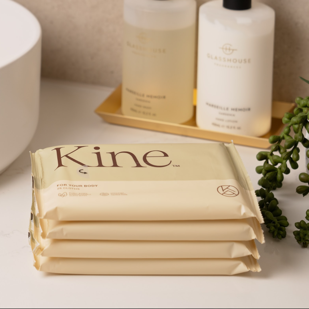 Stack of Kine  flushable wipes on a bathroom counter with bottles in the background
