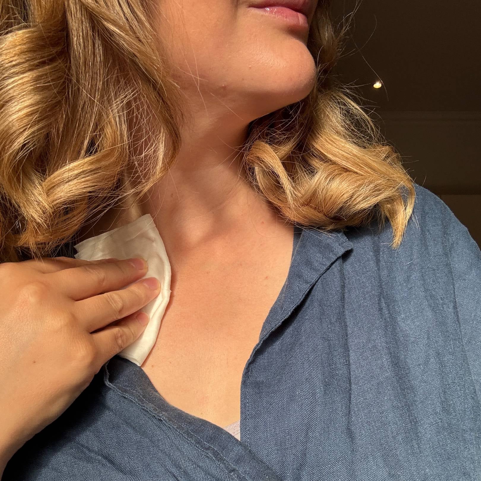 Person wearing a blue shirt with a blurred background using Kine flushable wipes