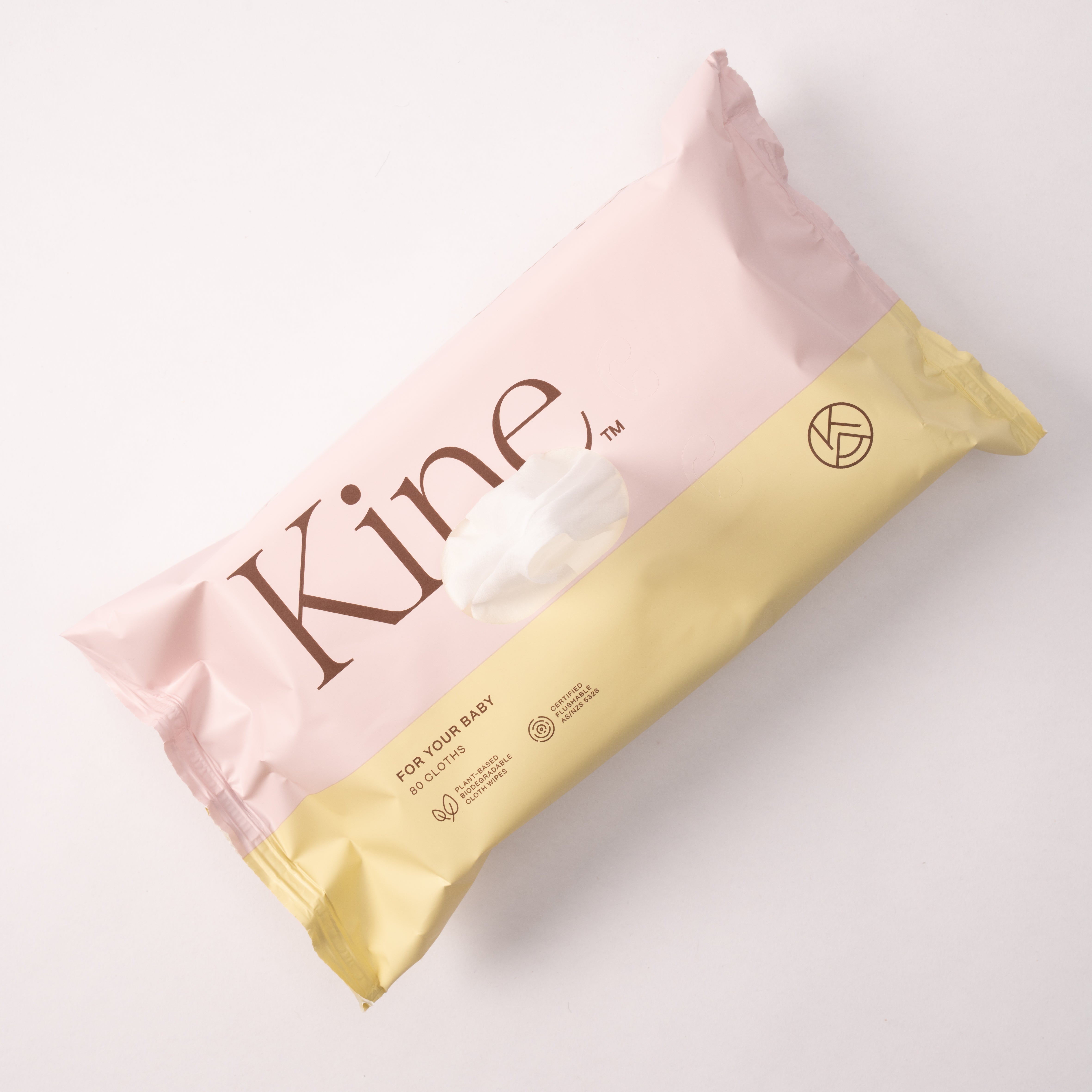 Pink and yellow package with 'Kine' branding on a light gray background. Baby flushable wipes, gentle baby wipes, flushable compostable wipes, flushable wipes Australia